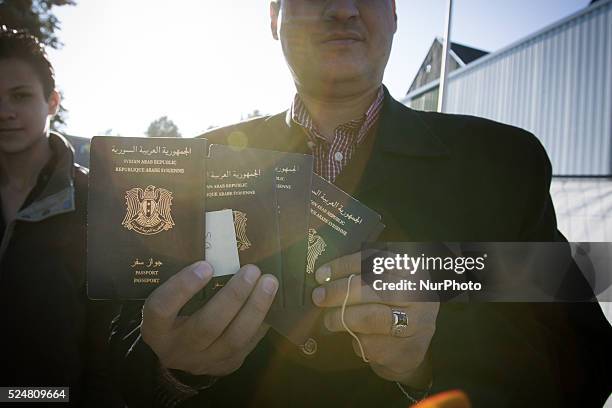Man shows the passports of his family whom he fled with from Syria. His wife is currently still lilving in his hometown of Homs. His brother and...