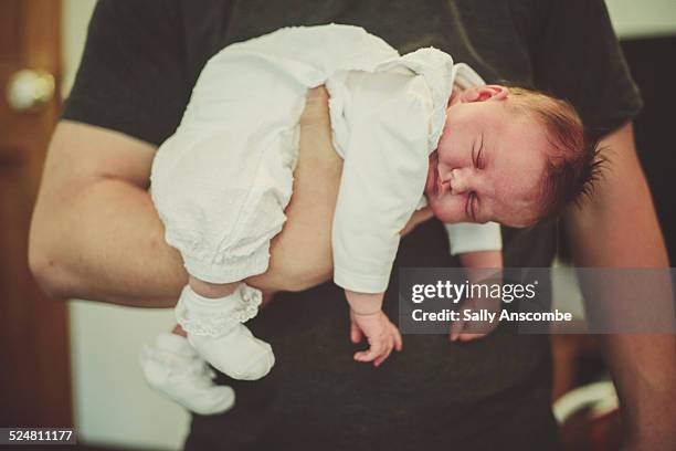 father holding his newborn baby daughter - girls in socks stockfoto's en -beelden