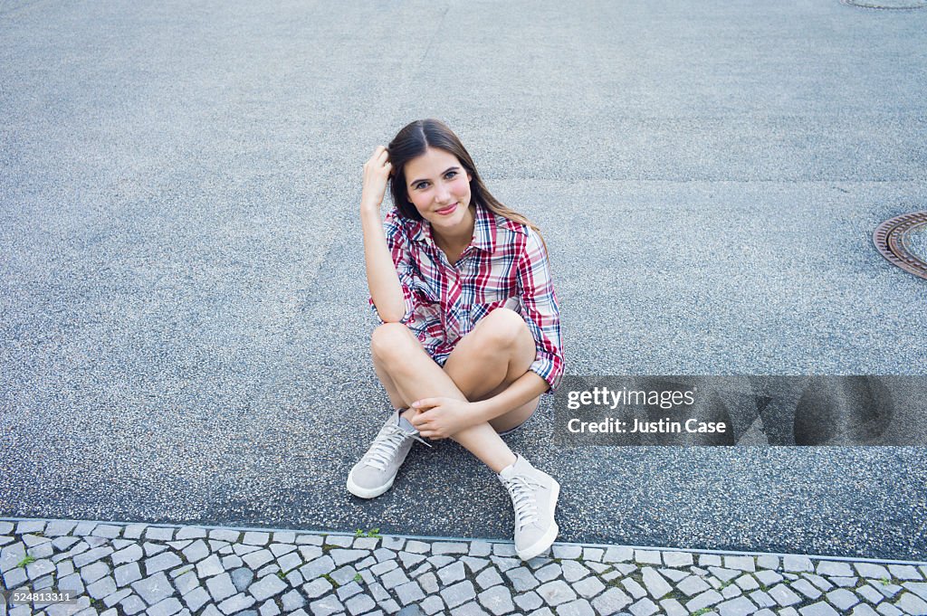 Woman smiling and sitting on the street