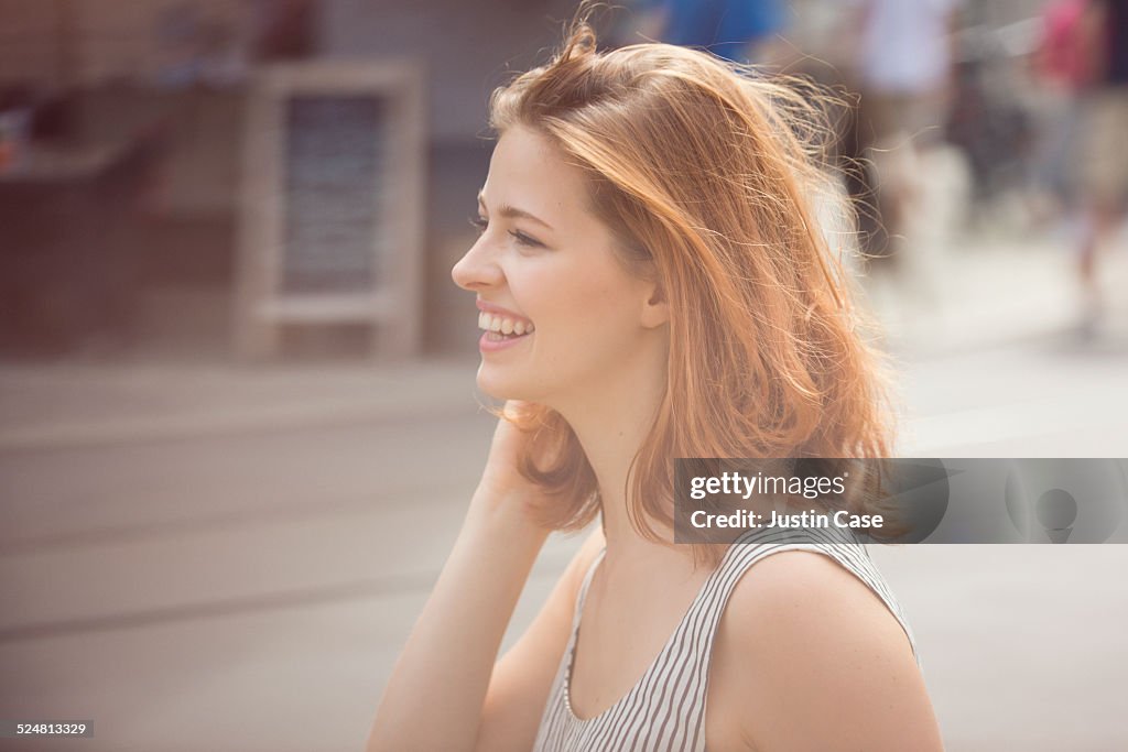 Portrait of a woman laughing in the sunny city