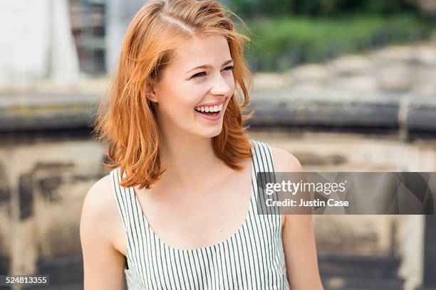 close portrait of a woman laughing outdoors - alleen één jonge vrouw stockfoto's en -beelden