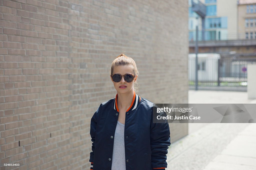 Girl wearing sunglasses in a sunny street