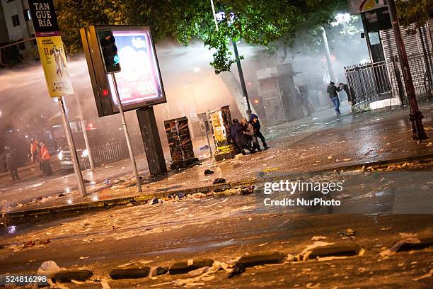 Fans try to hide from the water cannon used by riot police to disperse the multitud of fans after some attacked the police.