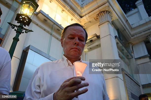 Man lits a candle during a commemorate to victims, who die in a bomb blast on August 17, at the Erawan Shrine in Bangkok, Thailand on August 24, 2015.