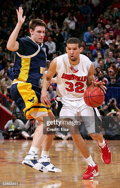 Francisco Garcia of the Louisville Cardinals moves the ball past Mike Gansey of the West Virginia Mountaineers during the Elite 8 game of the NCAA...