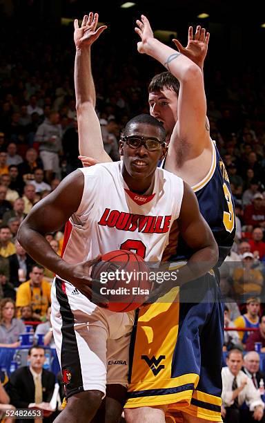 Juan Palacio of the Louisville Cardinals pulls down a rebound in front of Kevin Pittsnogle of the West Virginia Mountaineers during the Elite 8 game...