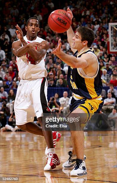 Larry O'Bannon of the Louisville Cardinals passes the ball past Johannes Herber of the West Virginia Mountaineers during the Elite 8 game of the NCAA...