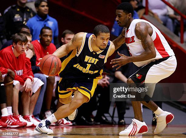 Collins of the West Virginia Mountaineers drives around Taquan Dean of the Louisville Cardinals during the Elite 8 game of the NCAA Division I Men's...