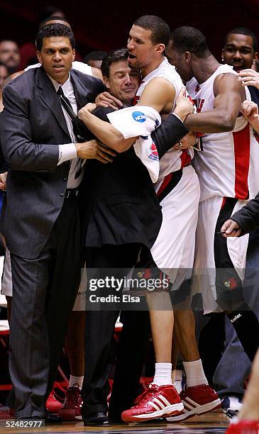 Head coach Rick Pitino is hugged by Francisco Garcia of the Louisville Cardinals after the Cardinals defeated the West Virginia Mountaineers in...