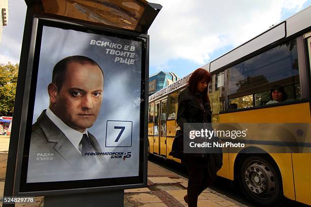 Bulgarians traveling by a bus walk past a pre-election poster at a bus station of Reformatorski blok party in the town of Varna east of the Bulgarian...