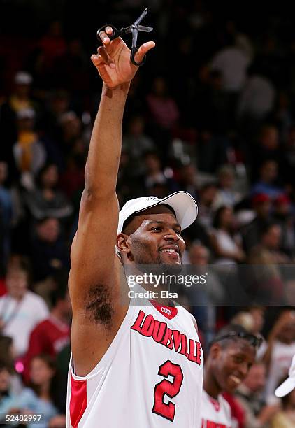 Ellis Myles of the Louisville Cardinals prepares to cut down the net after the Cardinals' victory over the West Virginia Mountaineers in overtime...