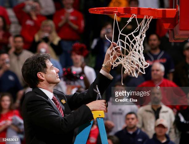 Head coach Rick Pitino of the cuts down the net after the Cardinals' victory over the West Virginia Mountaineers in overtime during the Elite 8 game...
