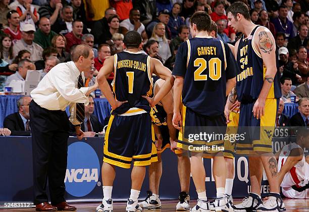 Head coach John Beilein of the West Virginia Mountaineers talks to his team during a timeout in the game against the Louisville Cardinals during the...