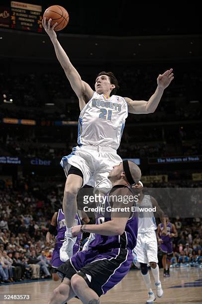 Eduardo Najera of the Denver Nuggets goes to the basket against Mike Bibby of the Sacramento Kings on March 26, 2005 at the Pepsi Center in Denver,...