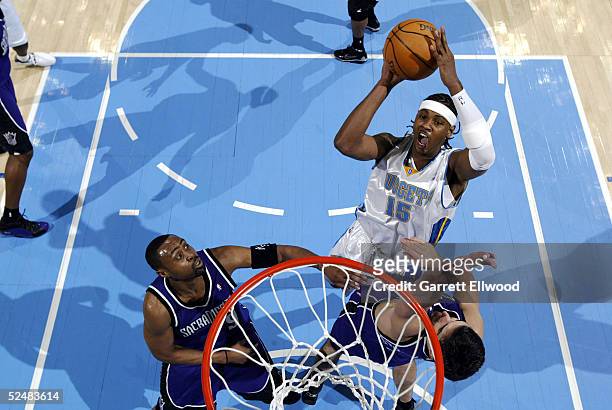 Carmelo Anthony of the Denver Nuggets goes to the basket against Peja Stojakovic of the Sacramento Kings on March 26, 2005 at the Pepsi Center in...
