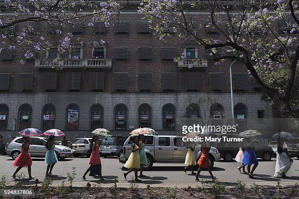 Schoolgirls take part in a small street carnival along the streets of downtown, Harare, Zimbabwe on October 10th 2015. There is a veneer of...