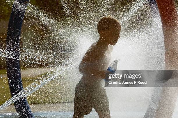 Anthony Mills dashes through a series of water jets at Osage Park in Wichita, Kansas on July 18, 2006. The temperature in Wichita on Tuesday soared...