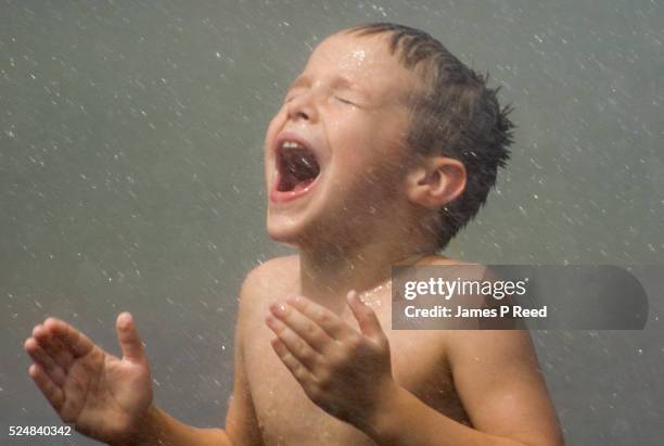 An unidentified boy happily reacts to cool water sprayed by an off-camera fire truck at the Sedgwick County Zoo in Wichita, Kansas on July 14, 2006....