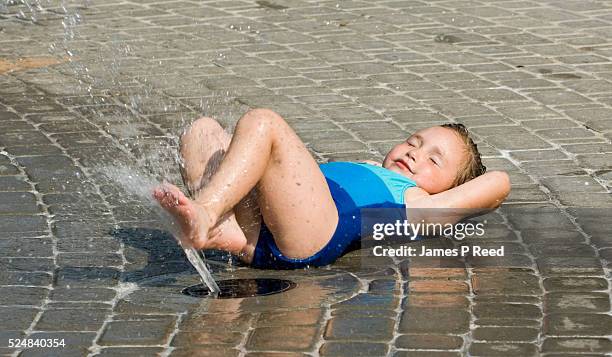 Ann Osborn tries to cool off with the help of an interactive fountain at Central Riverside Park in Wichita, Kansas on July 18, 2006. The temperature...