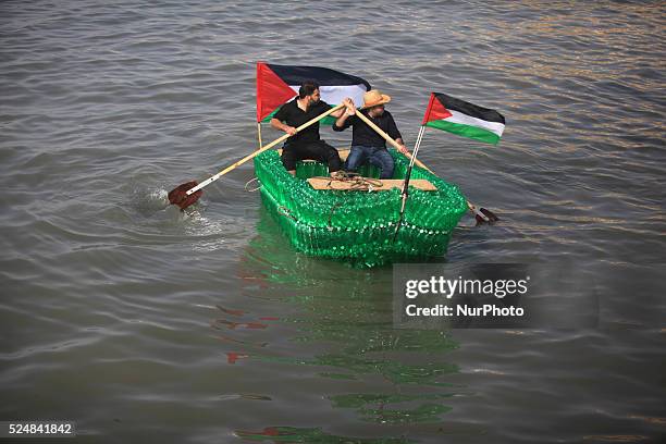 Young Palestinians on their boat made from remnants of empty plastic bottles inside the port of Gaza City