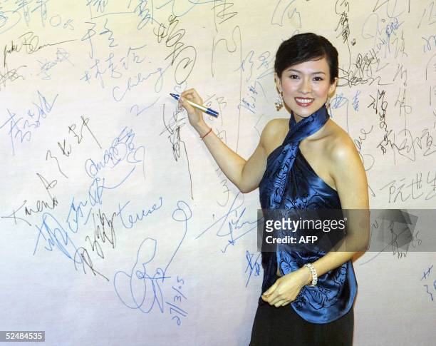 Chinese actress Zheng ZiYi signs her name upon her arrival to attend the 24th annual Hong Kong Film Awards, 27 March 2005. This year's annual...