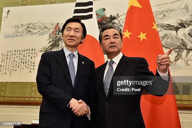 South Korean Foreign Minister Yun Byung-Se shakes hands with Chinese Foreign Minister Wang Yi before a meeting at the Diaoyutai State Guesthouse on...