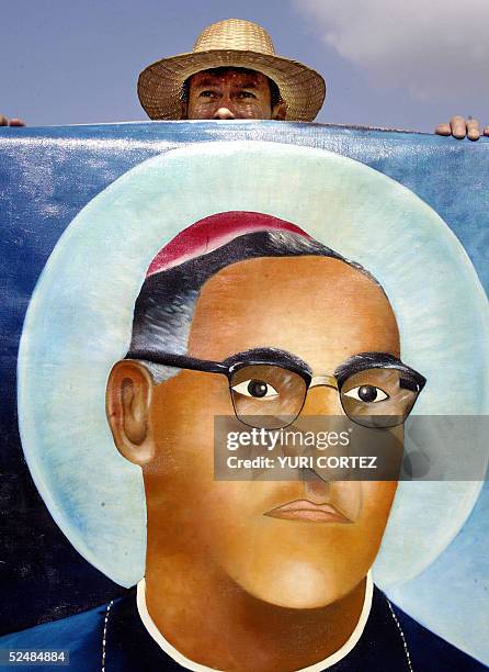 Un catolico seguidor del asesinado arzobispo monsenor Oscar Arnulfo Romero carga su retrato el 27 de marzo de 2005 durante una peregrinacion con la...