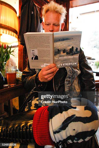 Man on April 30, 2015 in Leiden, Netherlands, is seen the recently released book by Dutch author Joris Luyendijk who spent three years interviewing...