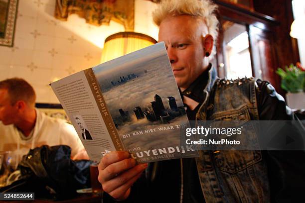 Man on April 30, 2015 in Leiden, Netherlands, is seen the recently released book by Dutch author Joris Luyendijk who spent three years interviewing...