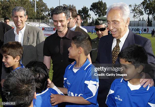Portuguese soccer coach Jose Mourinho and Israeli vice Prime Minister Shimon Peres pose for a picture with Israeli and Palestinian children at the...