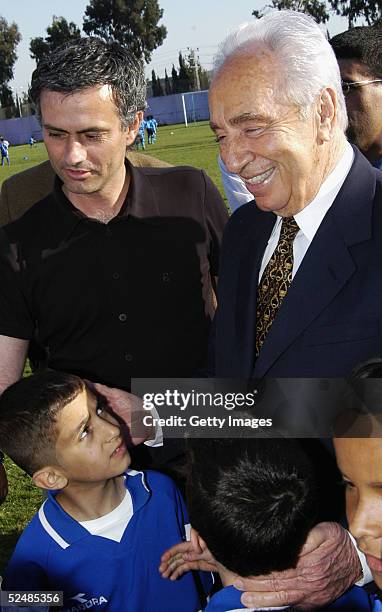 Portuguese soccer coach Jose Mourinho and Israeli vice Prime Minister Shimon Peres pose for a picture with Israeli and Palestinian children at the...