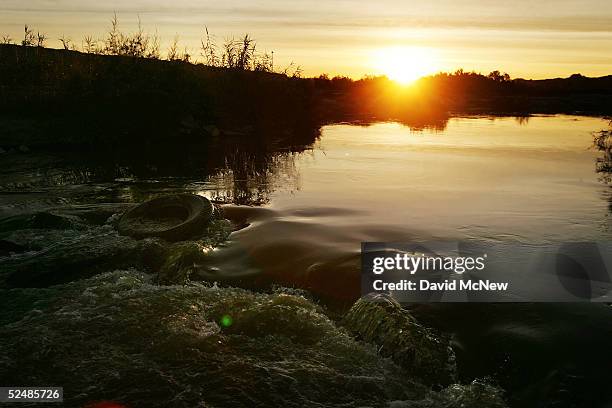 Water flows past a tire in the New River, reportedly the most polluted river in the U.S. And down which illegal immigrants float across the US/Mexico...