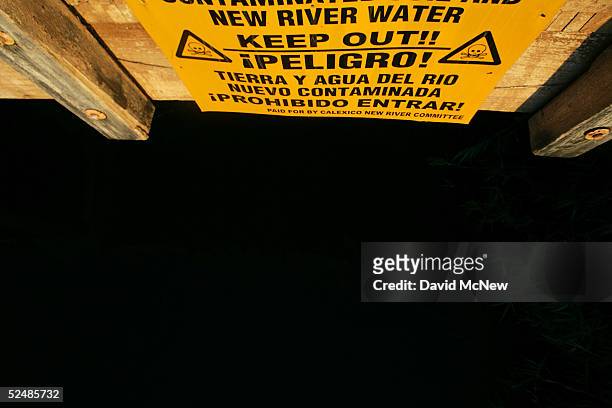 Sign on a bridge warns of the danger of entering the New River, reportedly the most polluted river in the U.S. And down which illegal immigrants...