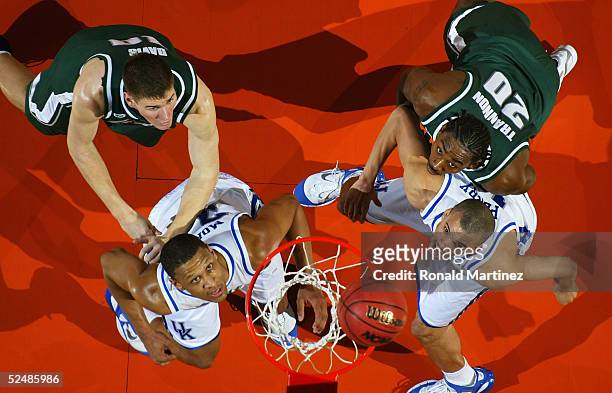 Matt Trannon and Paul Davis of the Michigan State Spartans watch the ball on the basket with Bobby Perry and Randolph Morris of the Kentucky Wildcats...