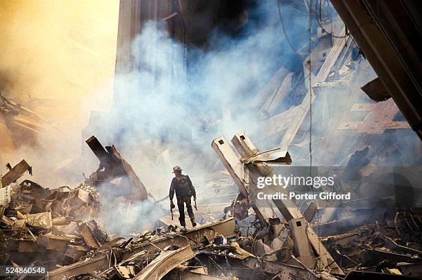 The rubble of the World Trade Center smoulders following a terrorist attack September 11, 2001 in New York. A hijacked plane crashed into and...