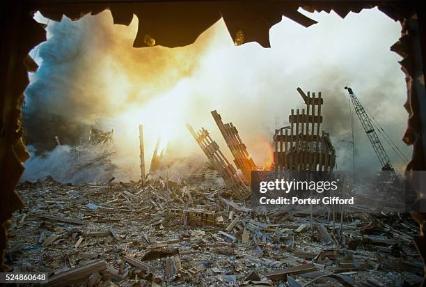 The rubble of the World Trade Center smoulders following a terrorist attack September 11, 2001 in New York. A hijacked plane crashed into and...
