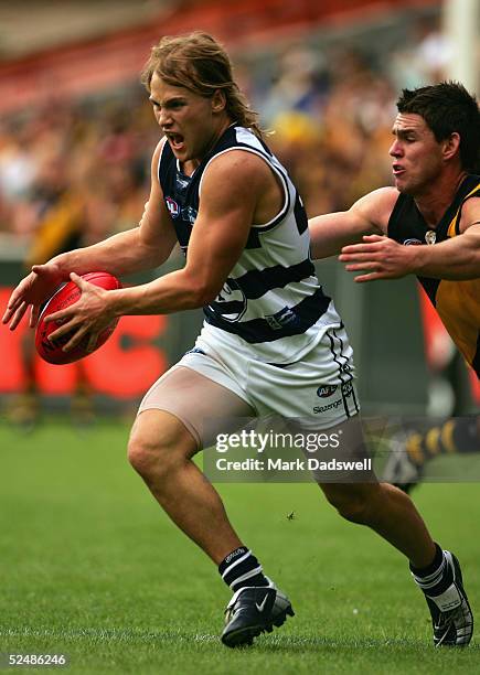 Gary Ablett Jnr of the Cats avoids the tackle from Chris Newman of the Tigers during the round one AFL match between the Richmond Tigers and the...