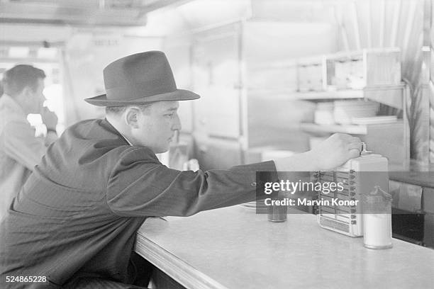 Diner selecting a song from a counter-mounted extension of the jukebox at Johnny's Diner in Somerville, New Jersey, 1950.