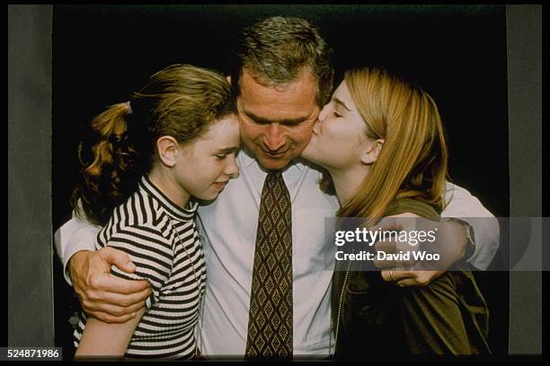 Governor of Texas George W. Bush hugging his daughters Barbara and Jenna.