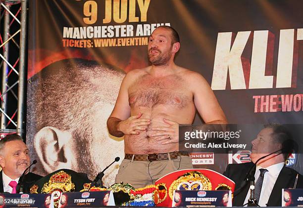 Bare chested WBO, WBA and IBO heavyweight champion Tyson Fury speaks after removing his shirt during Tyson Fury and Wladimir Klitschko head to head...