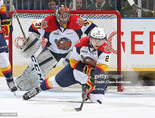 Mitchell Byrne of the Erie Otters clears a puck away for teammate Devin Williams during action against the London Knights in Game Three of the OHL...