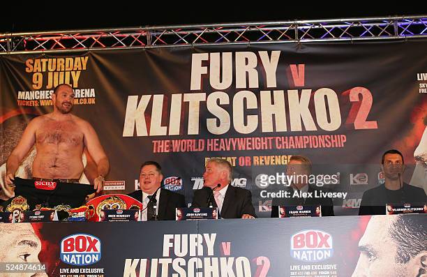 Reigning WBO, WBA and IBO heavyweight champion Tyson Fury removes his shirt as promoter Mick Hennessy, commentator John Rawling, promoter Frank...