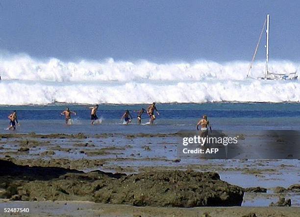 File photo dated 26 December 2004 shows tourists caught by the first of six tsunami rolling towards Hat Rai Lay Beach, near Krabi in southern...