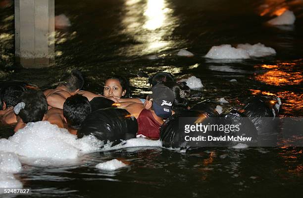 Group of people use inner tubes to float down the New River, reportedly the most polluted river in the US, after illegally crossing the US/Mexico...