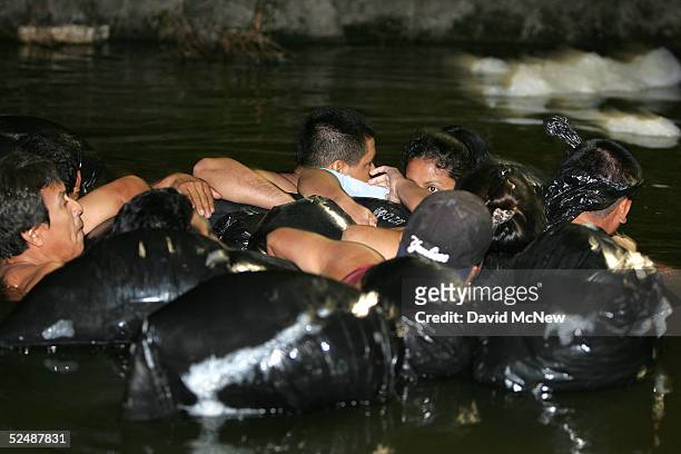Group of people use inner tubes to float down the New River, reportedly the most polluted river in the US, after illegally crossing the US/Mexico...