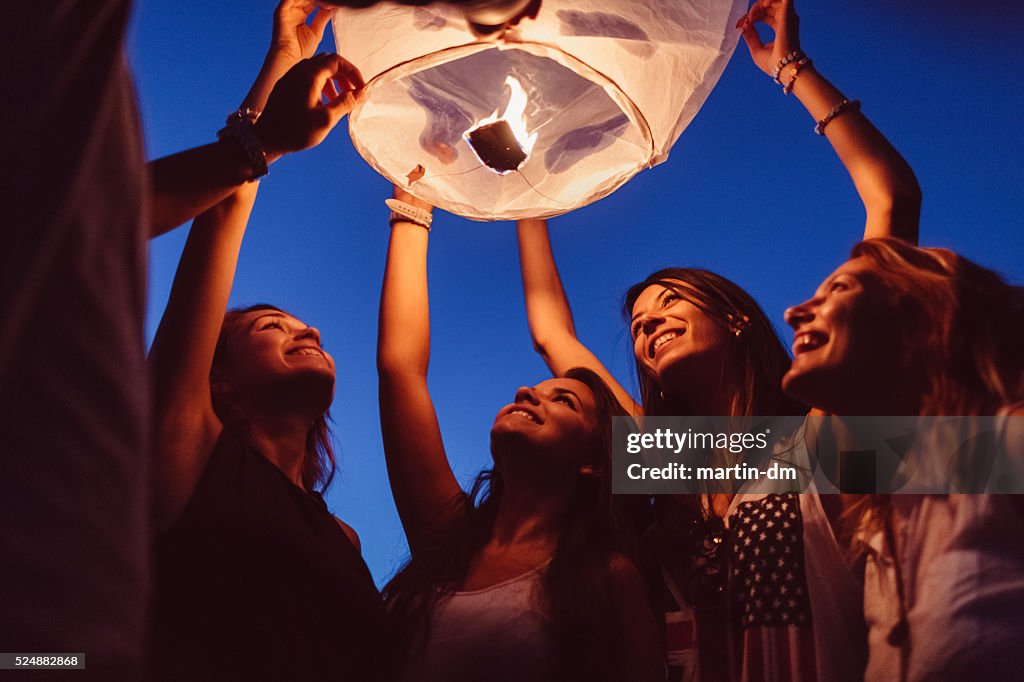 Friends releasing paper lantern