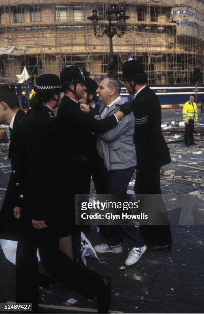 Protestor confronts police at the the scene of the Poll Tax demonstration and subsequent riot in Trafalgar Square, London, 31st March 1990.