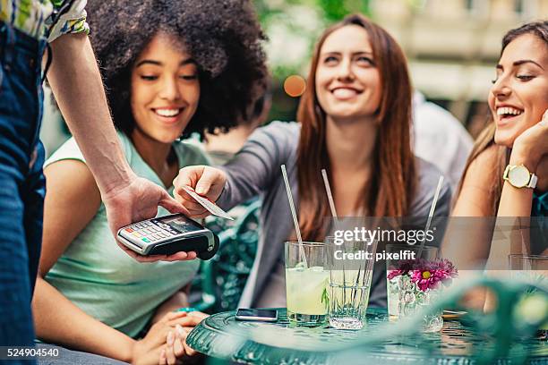 freundinnen im café die zahlung - geld verleihen freunde stock-fotos und bilder