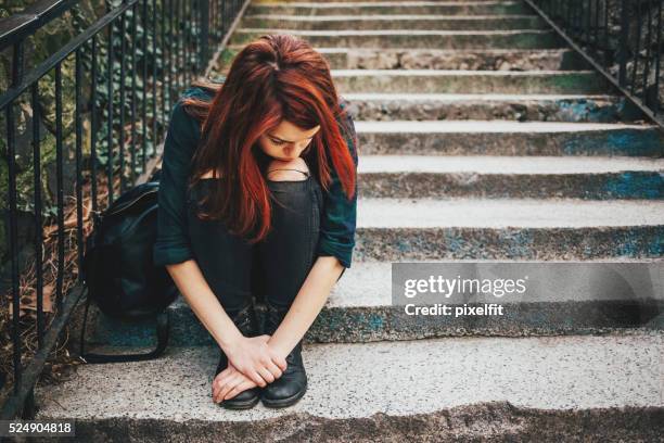 traurig einsam sitzendes mädchen auf treppe - teenager scared stock-fotos und bilder
