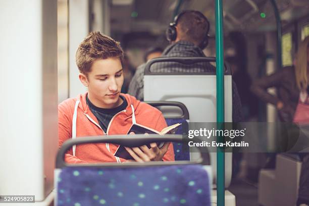adolescente ragazzo leggendo un libro sul tram - tram foto e immagini stock
